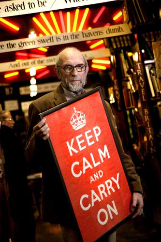 Man holding original Keep Calm and Carry On poster